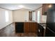 Open kitchen with dark wood cabinets, black appliances, and wood-look floors at 31 Blue Water Dr, Cicero, IN 46034