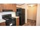 Modern kitchen with dark wood cabinets, black appliances, and granite countertops at 31 Blue Water Dr, Cicero, IN 46034