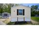 Tan mobile home with dark shutters and nautical rope accents at 29 Blue Water Dr, Cicero, IN 46034