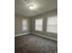 Spacious living room with neutral carpeting and three windows at 815 W 22Nd St, Anderson, IN 46016