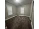 Bright bedroom with neutral carpeting and two windows at 815 W 22Nd St, Anderson, IN 46016