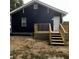 Back exterior view of a navy blue house with a wooden deck at 815 W 22Nd St, Anderson, IN 46016