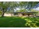 Brick ranch house with a covered porch and spacious lawn at 2129 Woodcrest Rd, Indianapolis, IN 46227
