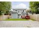 Rear view of charming house, deck, fenced yard, and gravel parking at 1136 W 35Th St, Indianapolis, IN 46208