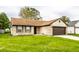 Brick ranch home with brown garage door and green lawn at 4130 Robertson Ct, Indianapolis, IN 46228