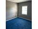 Simple bedroom with gray walls and blue carpeting, window at 6104 Madison Ave, Indianapolis, IN 46227
