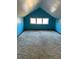 Bright bedroom with blue walls, three windows, and carpet at 6104 Madison Ave, Indianapolis, IN 46227
