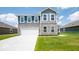 Two-story home with gray siding, stone accents, and a white garage door at 1448 Buttercup Ln, Shelbyville, IN 46176