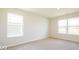 Spacious bedroom with neutral carpeting and two windows at 1448 Buttercup Ln, Shelbyville, IN 46176