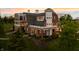 Impressive aerial showcasing a brick farmhouse with multiple levels and balconies at 9825 Windy Hills Dr, Zionsville, IN 46077