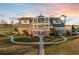 Luxury farmhouse with expansive patio and landscaped grounds at sunset at 9825 Windy Hills Dr, Zionsville, IN 46077