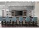Home bar with seating, a TV, and built-in shelving at 9825 Windy Hills Dr, Zionsville, IN 46077