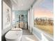 Luxurious bathroom with soaking tub, large window, and modern fixtures at 9825 Windy Hills Dr, Zionsville, IN 46077
