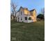 Two-story house with light beige siding, a large yard, and mature trees at 213 E Broadway St, Alexandria, IN 46001
