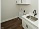 Laundry room with a sink, white cabinets, and dark hardwood floors at 2749 Stones Bay Dr, Greenwood, IN 46143