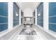 Elegant hallway with blue walls, marble floors, and columns leading to an elevator at 8751 Jaffa Court E Dr # 35, Indianapolis, IN 46260