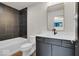 Modern bathroom with dark vanity, white countertop, and tile shower at 679 E 16Th St, Indianapolis, IN 46202