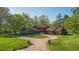 Brick house with circular driveway, surrounded by lush greenery at 8494 W Mulligan Ln, Columbus, IN 47201