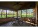 Bright sunroom with wicker furniture and golf course view at 8494 W Mulligan Ln, Columbus, IN 47201