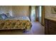 Cozy bedroom with a floral quilt, dresser, and large window with garden view at 8494 W Mulligan Ln, Columbus, IN 47201