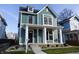 Two-story craftsman home with a teal exterior, white trim, and a welcoming front porch at 2133 N Talbott St, Indianapolis, IN 46202