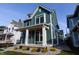 Two-story craftsman home with a teal exterior, white trim, and a welcoming front porch at 2133 N Talbott St, Indianapolis, IN 46202