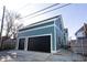 Two-car garage with black doors, teal exterior, and a gravel driveway at 2133 N Talbott St, Indianapolis, IN 46202