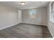 Spacious bedroom with grey walls and wood-look floors at 6233 Lafayette Rd, Indianapolis, IN 46278