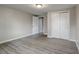 Spacious bedroom with grey walls, wood-look floors and double doors to closet at 6233 Lafayette Rd, Indianapolis, IN 46278