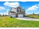 Two-story gray house with stone accents and a two-car garage at 7098 Portico Ln, McCordsville, IN 46055