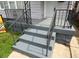 Gray front steps with black metal railings leading to the front door at 209 N Pershing Ave, Indianapolis, IN 46222