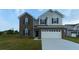 Two-story brick and vinyl home with a large white garage door and manicured lawn at 1184 Lakeshore Drive, Greenwood, IN 46143