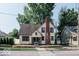 Full exterior view of a charming two-story house with a brick chimney and well-maintained lawn at 819 E 49Th St, Indianapolis, IN 46205