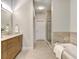 Modern bathroom with a soaking tub, glass shower, and wood cabinets at 319 E 16Th St # 202, Indianapolis, IN 46202
