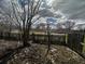Overgrown backyard with debris and trash needs significant cleanup at 904 N Penn St, Muncie, IN 47303