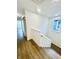 Modern white stairwell with hardwood floors and a simple handrail at 217 N Temple Ave, Indianapolis, IN 46201