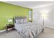 Bright bedroom with a grey bed, green accent wall, and window coverings at 450 E Ohio St # 321, Indianapolis, IN 46204