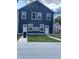 Rear view of a duplex with concrete driveway and grassy yard at 221 N Temple Ave, Indianapolis, IN 46201