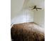 Bright attic bedroom with carpet, ceiling fan, and a door at 221 Kansas St, Indianapolis, IN 46225