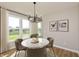 Bright dining room features a round table, neutral decor and large windows at 15269 Garden Mist Pl, Fishers, IN 46037