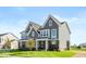 Gray and brick two-story home with side view showcasing large windows at 15269 Garden Mist Pl, Fishers, IN 46037