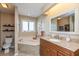 Bathroom boasts a corner tub, wood vanity, and a large mirror at 10706 Augusta Blvd, Fishers, IN 46037