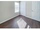 Bright bedroom with dark wood-look floors and white door at 3002 N Olney St, Indianapolis, IN 46218