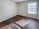 Spacious bedroom with dark wood-look floors and a large window at 3002 N Olney St, Indianapolis, IN 46218