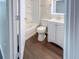 Clean bathroom with white vanity, tub, and dark tile floor at 3002 N Olney St, Indianapolis, IN 46218