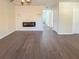 Living room with dark hardwood floors, electric fireplace and hallway access at 3002 N Olney St, Indianapolis, IN 46218