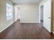 Spacious bedroom with dark wood-look floors and access to bathroom at 3002 N Olney St, Indianapolis, IN 46218