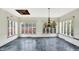 Sunroom with slate floor, many windows, and chandelier at 1311 Golden Hill Dr, Indianapolis, IN 46208