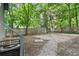 Backyard with gravel area, wooden fence, and mature trees at 332 Northern Ave, Indianapolis, IN 46208