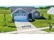 Curb appeal abounds at this charming one-story home, featuring a two-car garage and manicured lawn at 6941 E Bean Blossom Dr, Camby, IN 46113